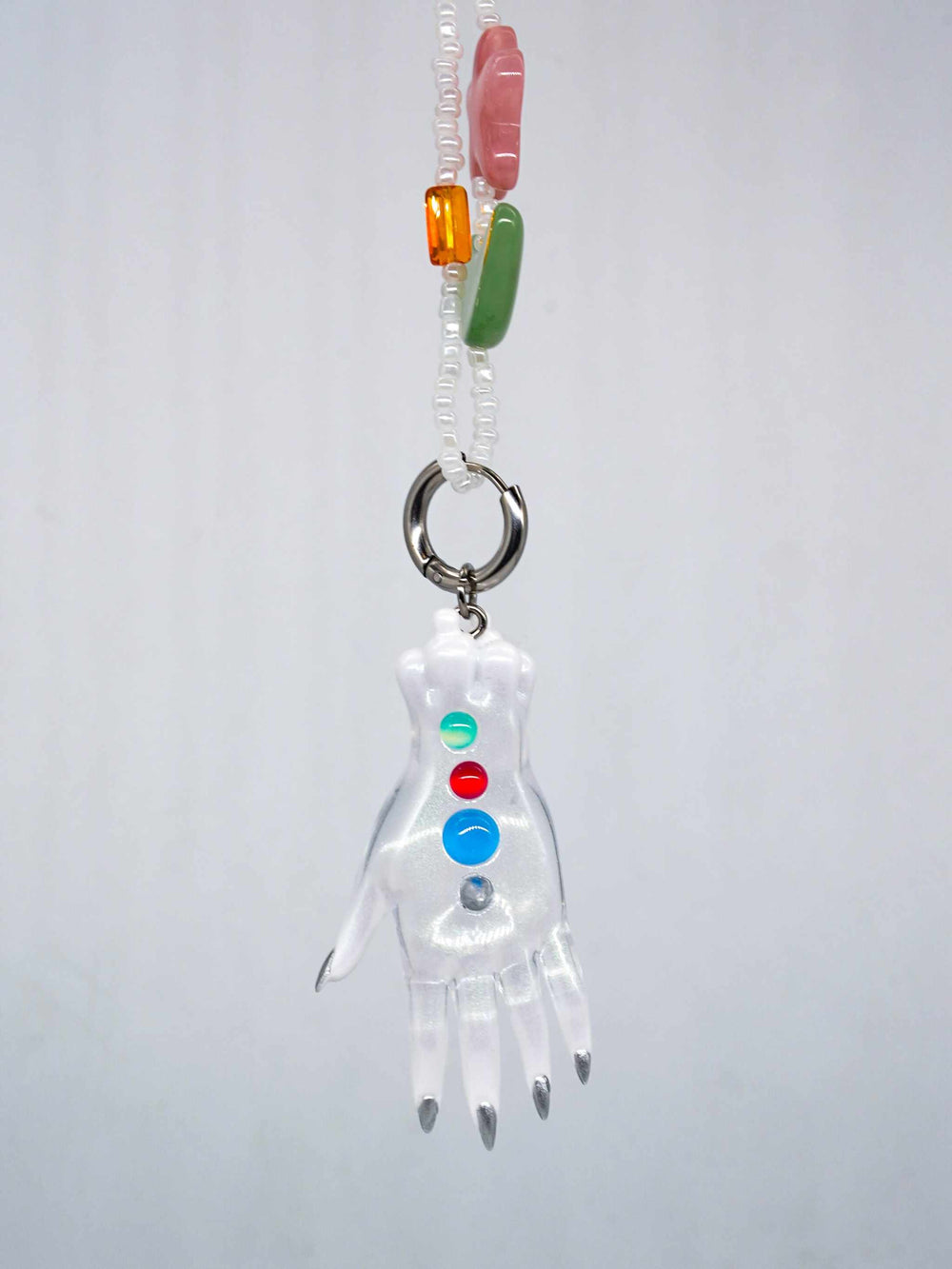 Colorful white monster hand pendant necklace with multicolored beads and playful design