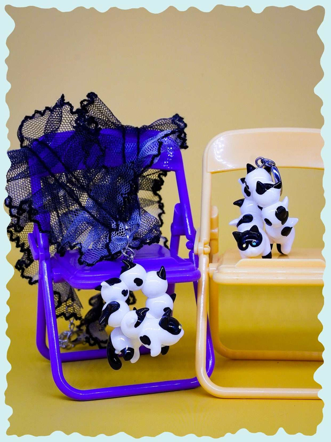 Tuxedo cat-shaped caterpillar necklace and earrings on colorful chairs.