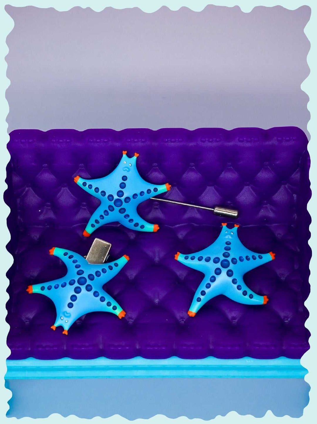 Vibrantly colored SeaStar cat hairclip and brooch in magenta and navy, made from polyurethane resins.