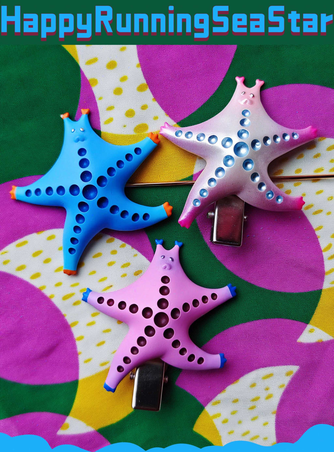 SeaStar cat hairclip and brooch in vibrant colors, featuring magenta and navy designs, displayed on a colorful background.