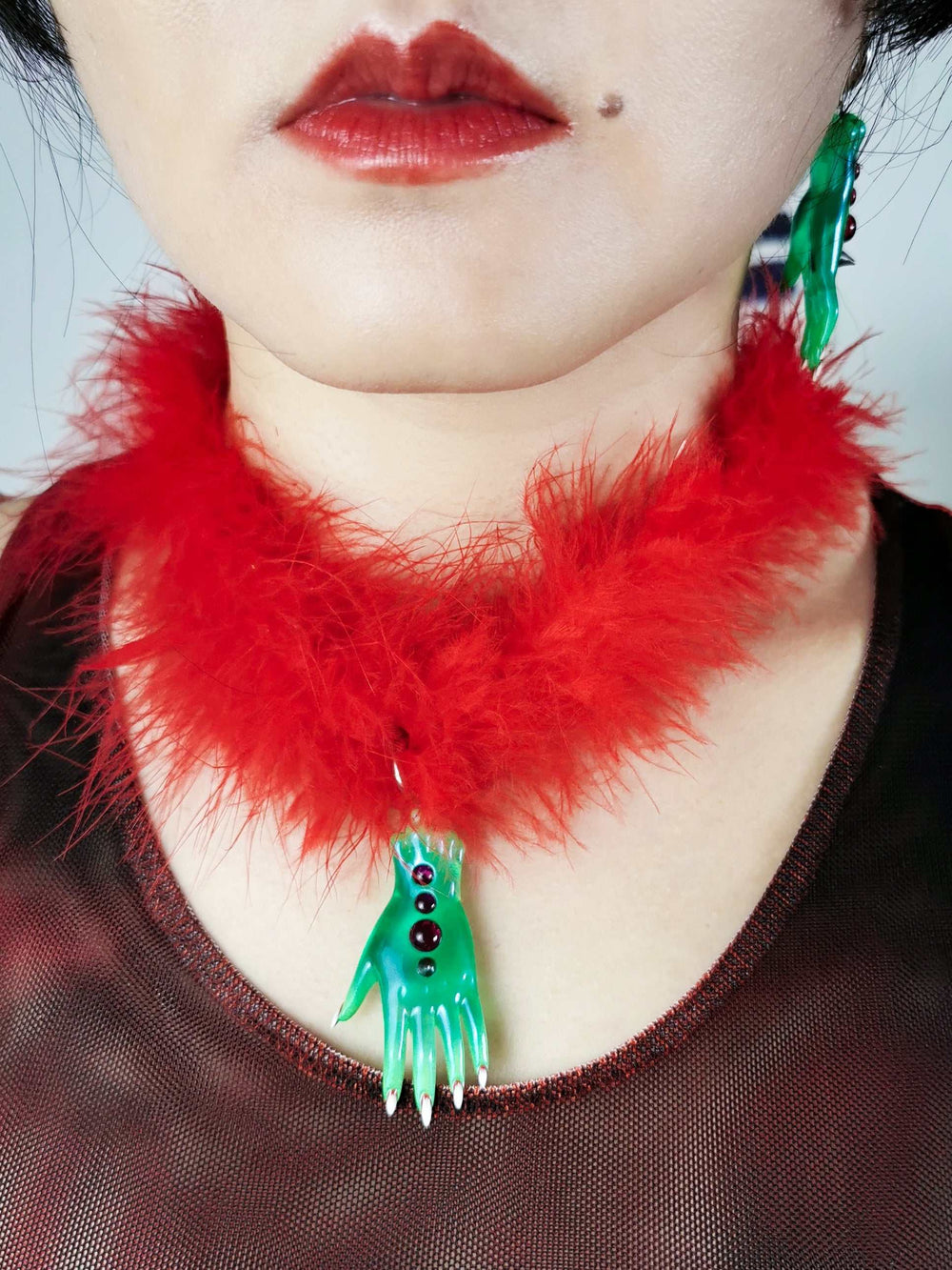 Green fairy goblin hand necklace with red feather choker and matching earring detail