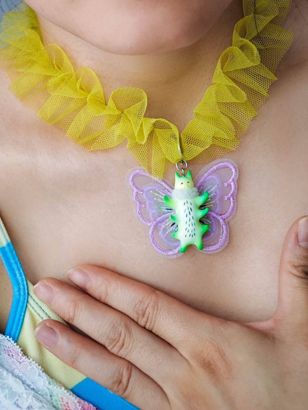 Butterfly cat necklace with green and purple design on a yellow snood.