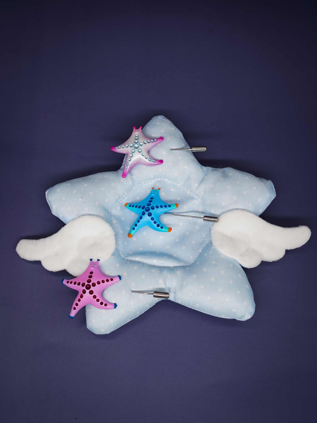SeaStar cat hairclip and brooch in pink and pearl color blocking on star-shaped cushion.