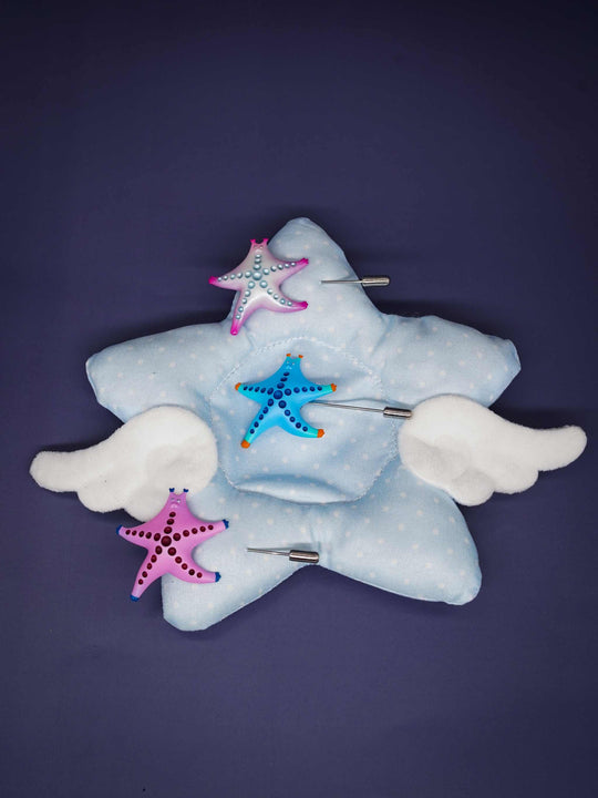SeaStar cat hairclip and brooch in pink and pearl color blocking on star-shaped cushion.