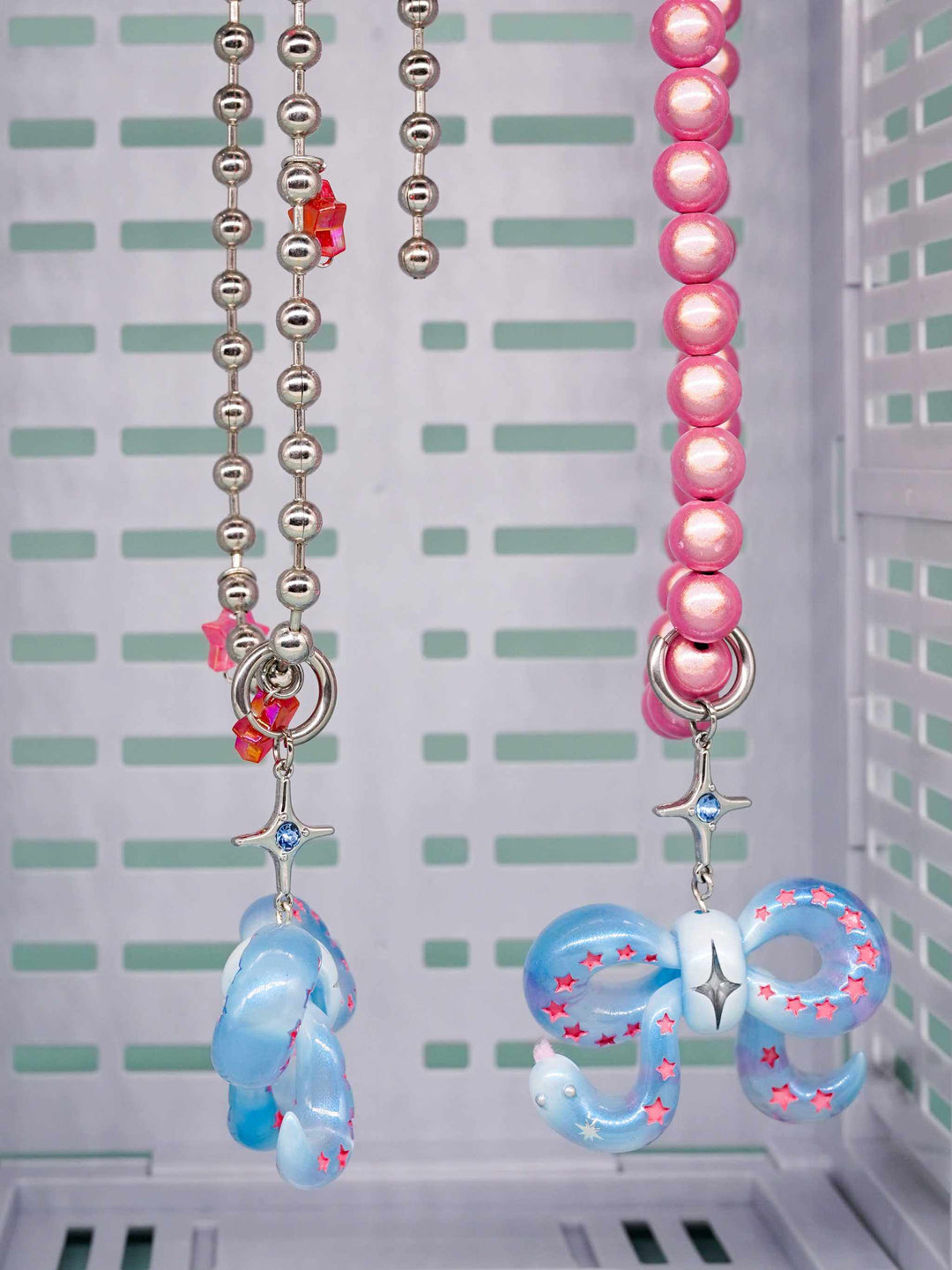 Ice blue snake bowtie necklace and earring set with pink star details and silver chains