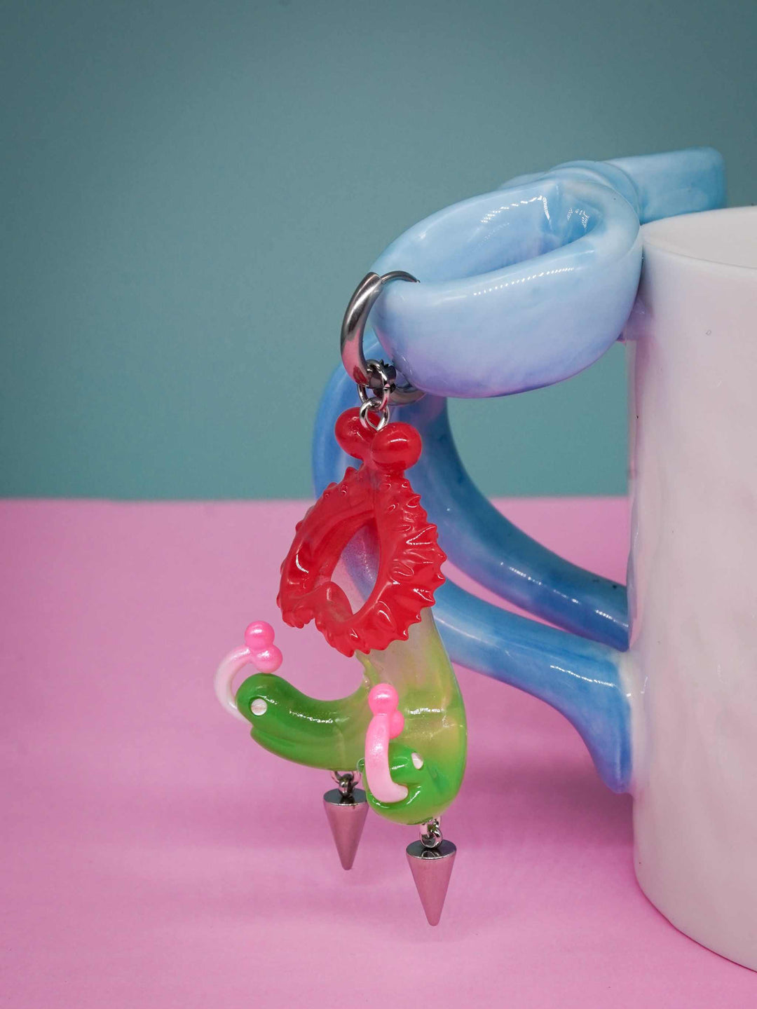 Twin-headed pitcher serpent earrings with cherry red and acid green colors, featuring serpent heads and metal spikes