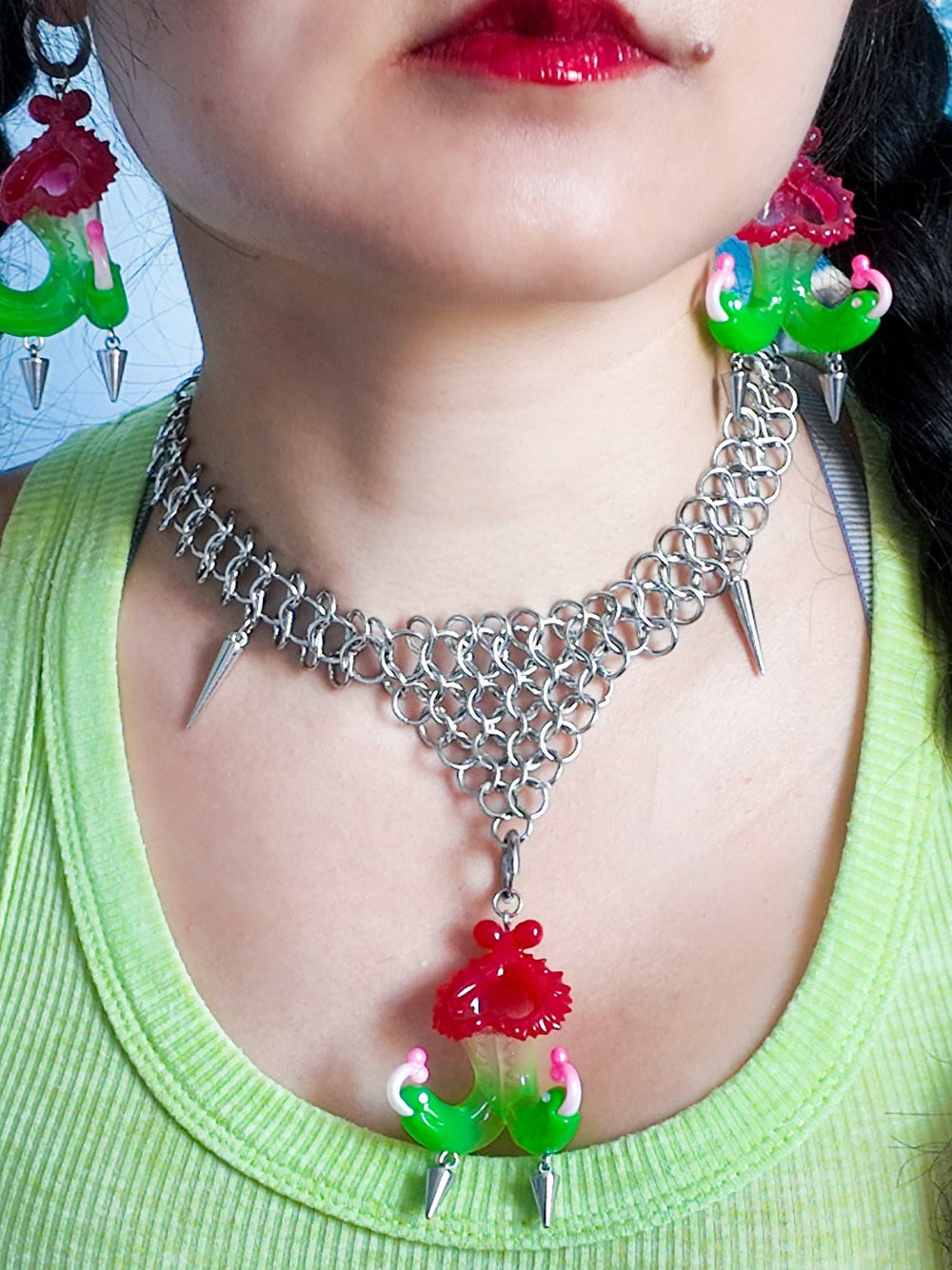 Twin-headed pitcher serpent earrings in translucent cherry red and acid green with metal spikes by Acid Candy