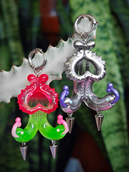 Twin-headed pitcher serpent earrings with violet tendrils and metallic details