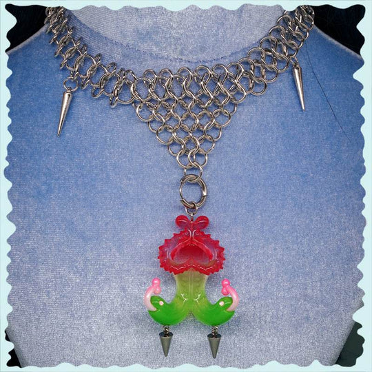 Twin-headed pitcher serpent earrings in translucent red, green, and pink with metal spikes and serpent heads design