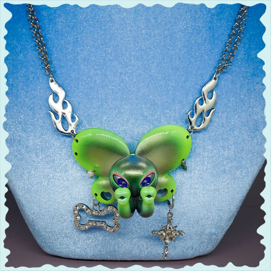Twin-Trunk Diva Elephant Necklace in metallic alien apple green with two trunks and blue-purple starry eyes